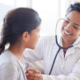 Smiling doctor using a stethoscope to examine a young patient, symbolizing future healthcare and HSA savings.