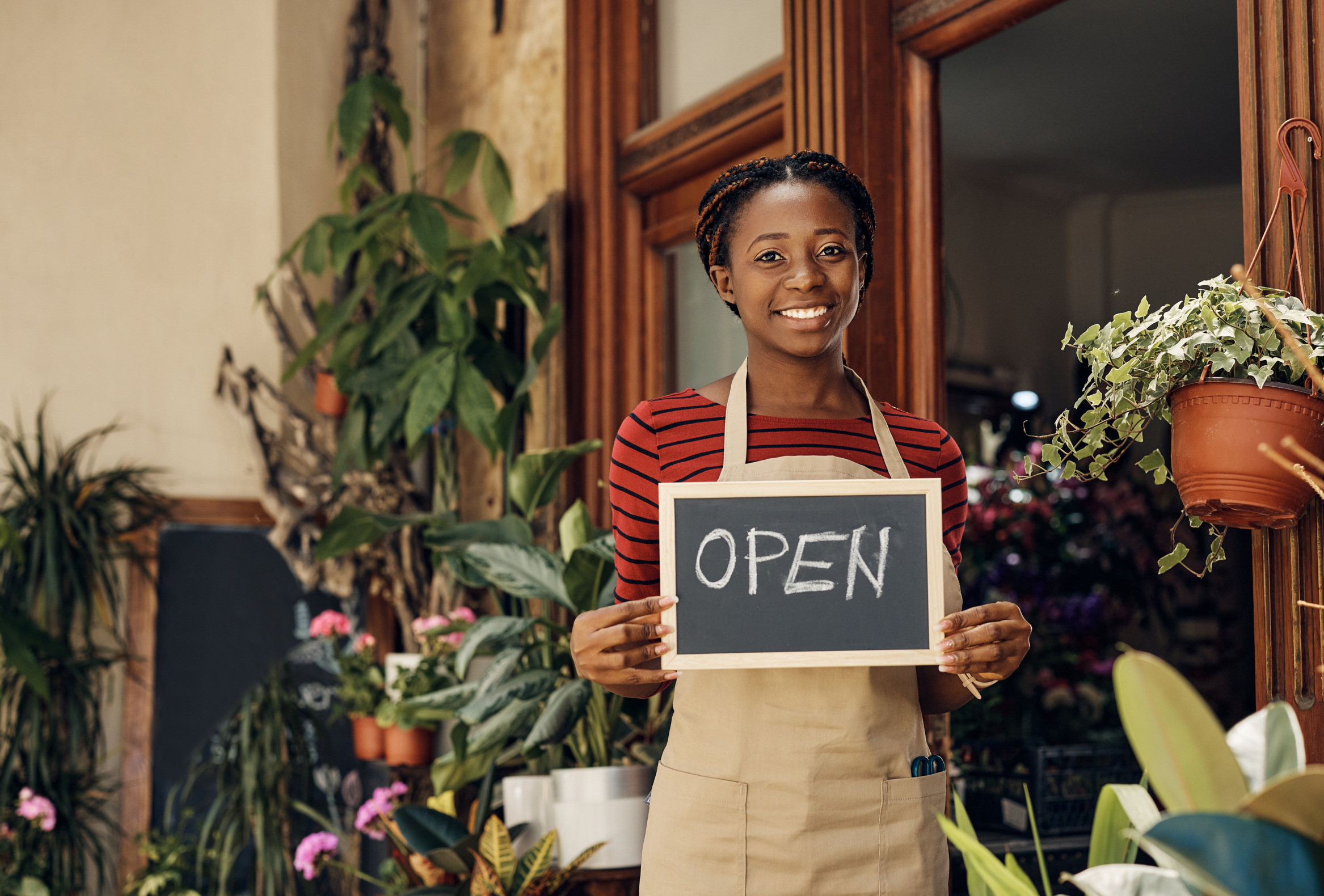 Smiling local business owner holding a tablet, representing convenient business checking that works for their needs.