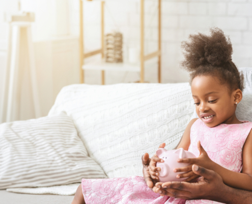 Father and daughter looking at a piggy bank, symbolizing family savings and the perfect spot for future financial goals.