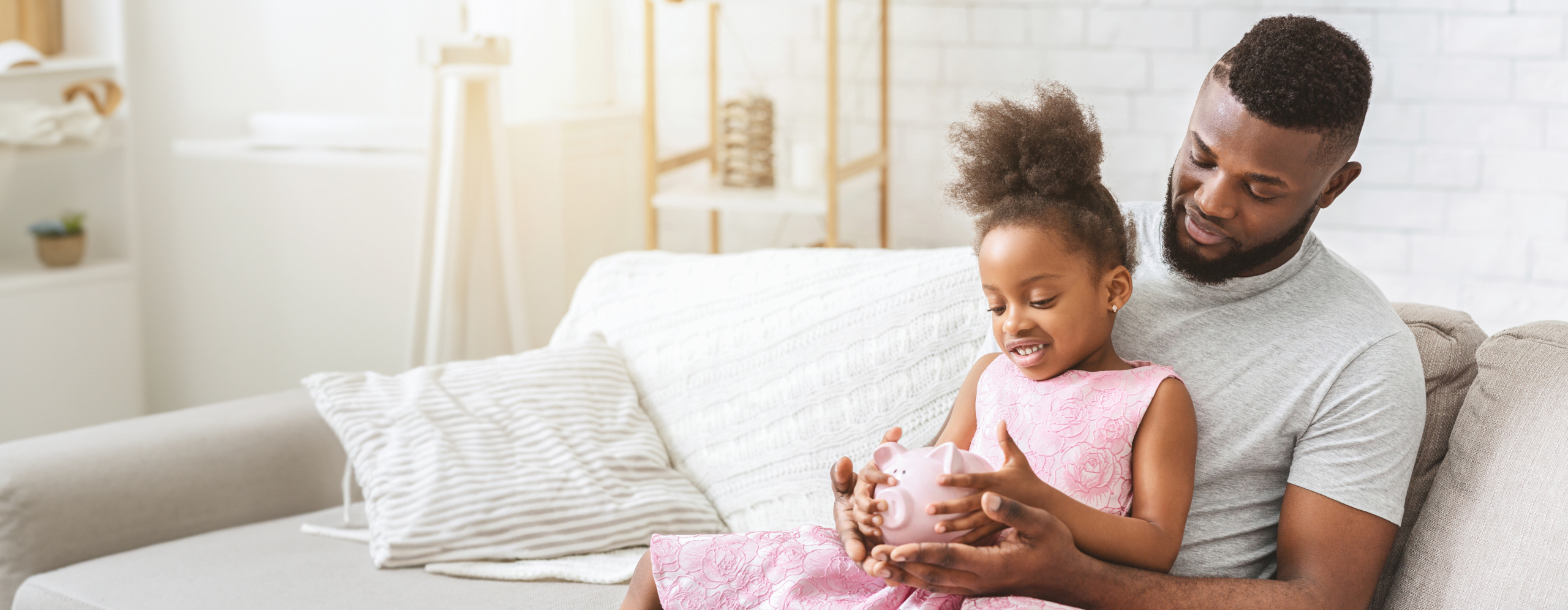 Father and daughter looking at a piggy bank, symbolizing family savings and the perfect spot for future financial goals.