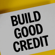 Calculator, magnifying glass and a sign that reads Build Good Credit.