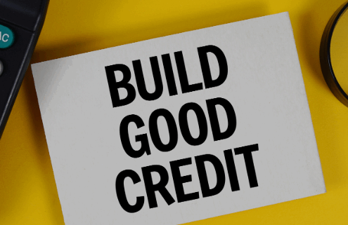 Calculator, magnifying glass and a sign that reads Build Good Credit.